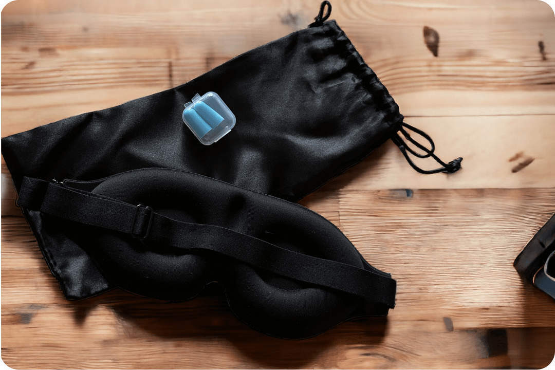 Sleeping mask on wood floor with case and earplugs